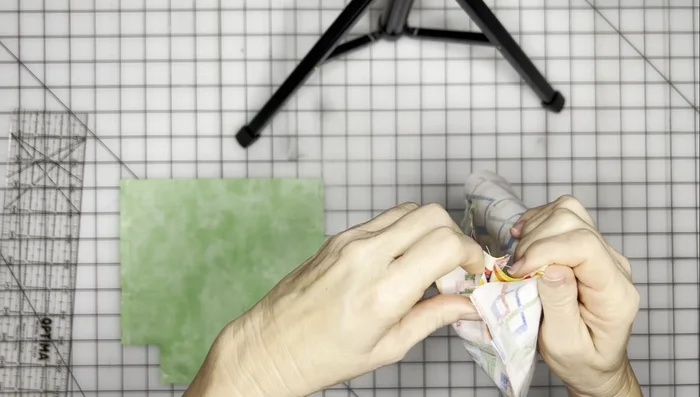Match up the seams of the main fabric and sew the box bottom corners, using a 0.5-inch seam allowance.