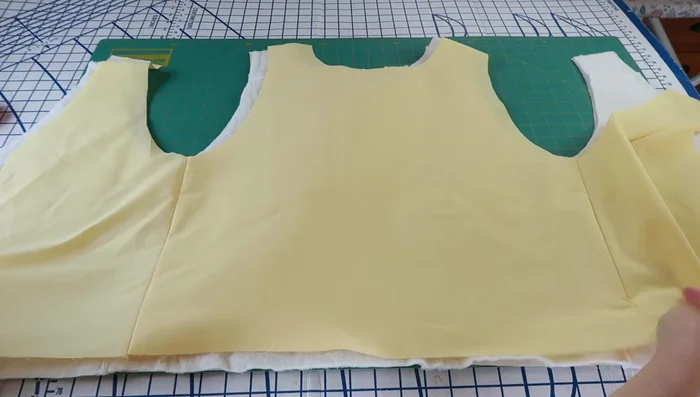 Sandwich quilt batting between outer and inner vest fabrics, pin, and mark quilting lines.