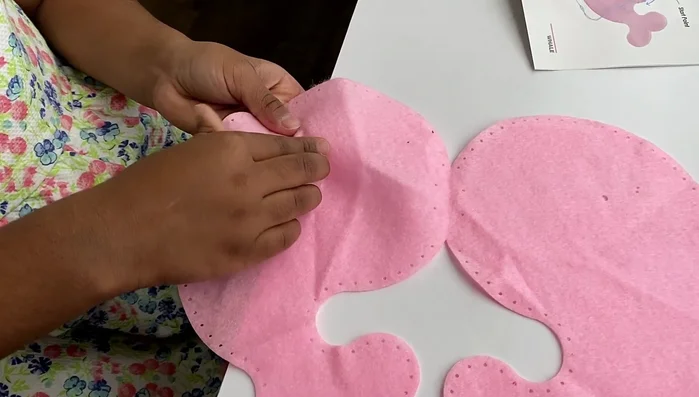 Attach the eyes: Secure the eye screws into the designated holes on the whale's felt face.