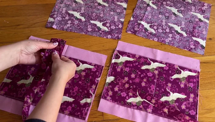 Fold the handles in half and place them at the top center of the bag, sew in place.