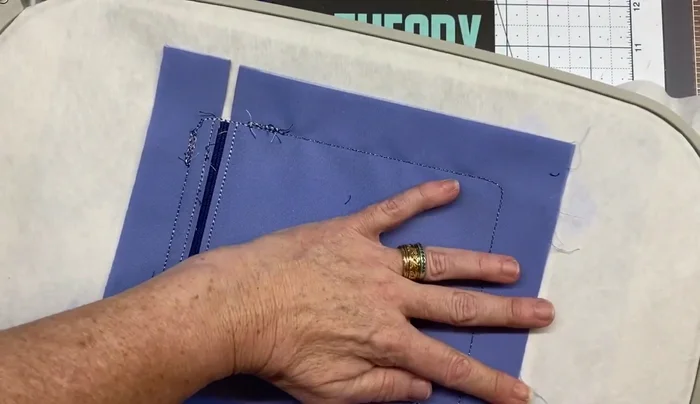 Flip the hoop, tape the lining piece, and run color stop 19.