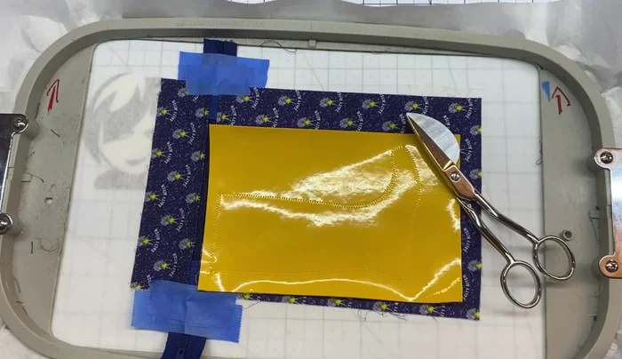 Trim the excess vinyl close to the stitching using appliqué cutting scissors.