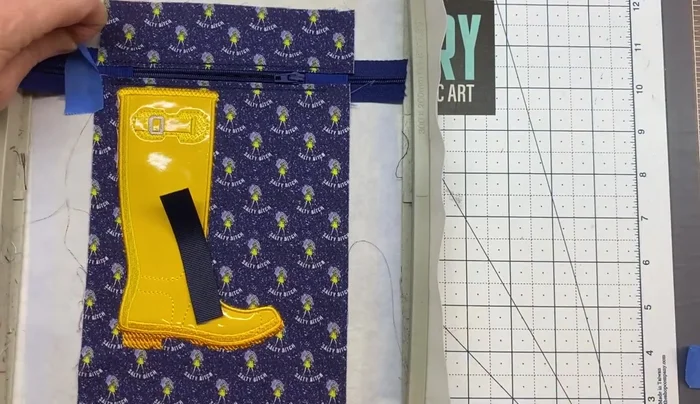 Attach the lobster claw or D-rings and ribbon assembly. Tape and run color stop 17.