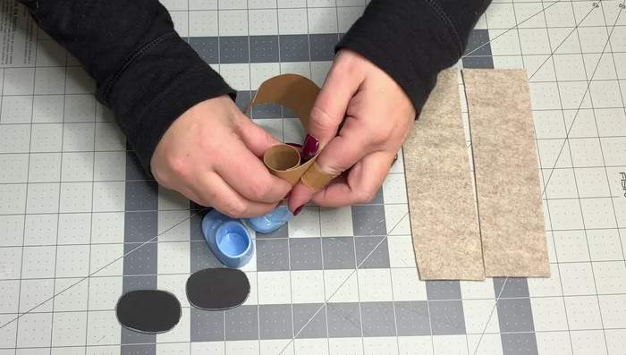 Wrap the craft paper around the inside of the booty, gluing it in place to provide stability. Glue the felt strips around the paper, overlapping by half an inch.