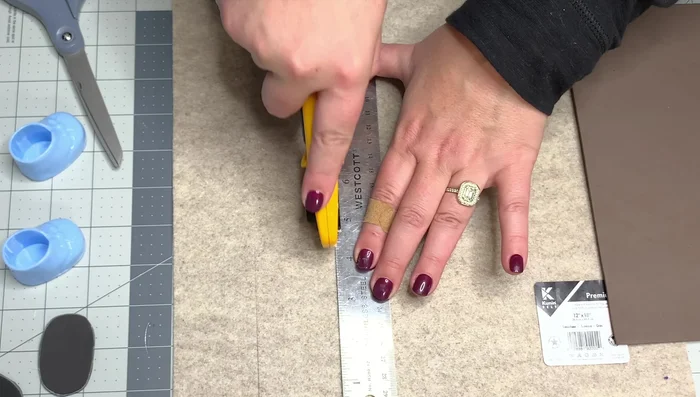 Wrap the craft paper around the inside of the booty, gluing it in place to provide stability. Glue the felt strips around the paper, overlapping by half an inch.