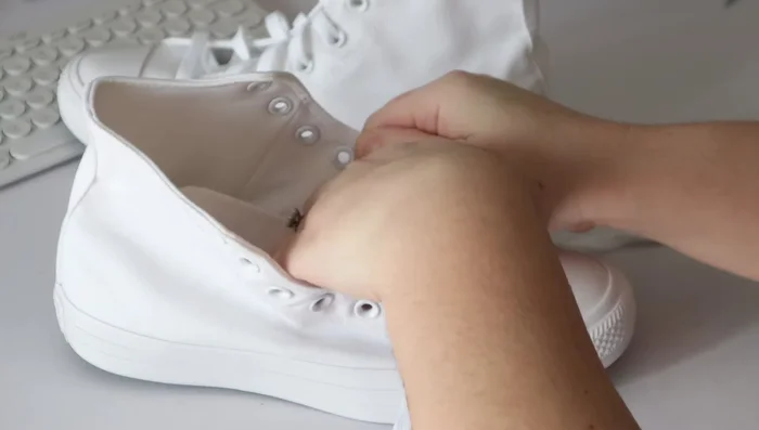 Unlace the shoes completely and tuck the tongue underneath the toe cap.