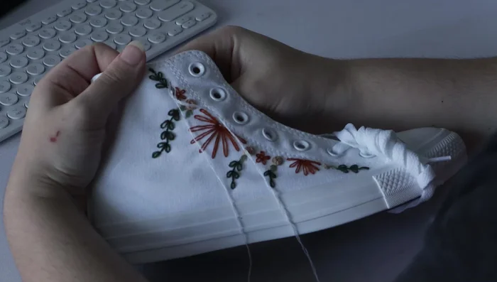 Add small accents near the leaves using French knots.