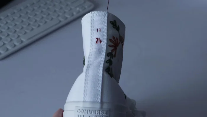 Stitch the wedding date onto the back of the shoes using straight stitches.