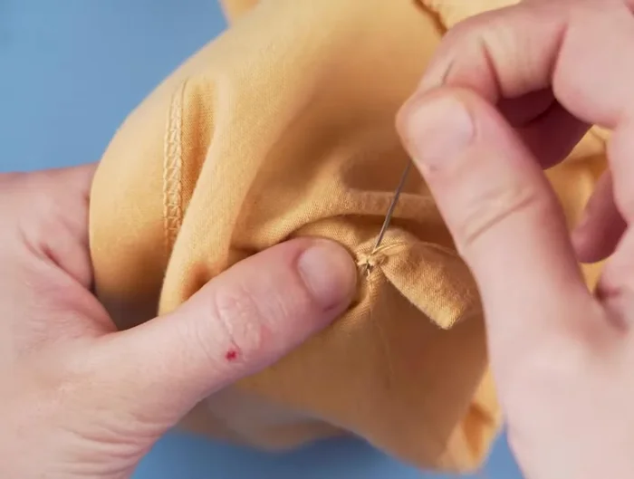 At the end of the hole, go in and out of the fabric in the same spot a few times to create another secure knot.