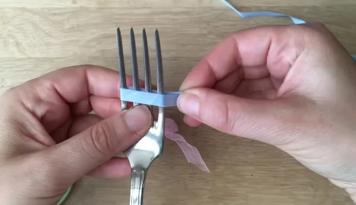 Wrap the ribbon around a fork, creating a 'V' shape with the longer piece underneath.