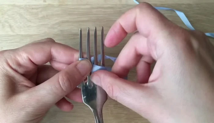 Bring the top ribbon to the back and then back up, keeping it neat and untwisted.