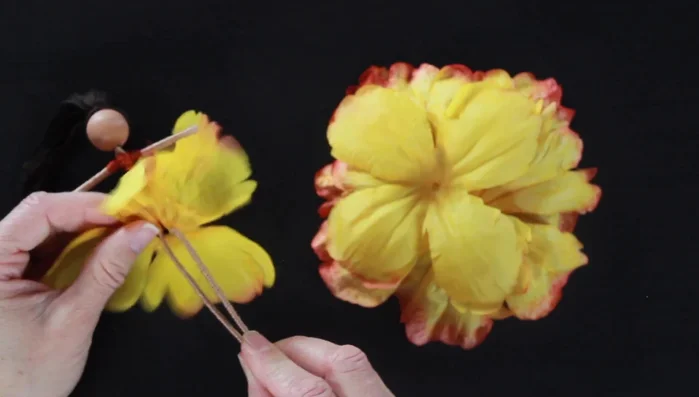 Attach the flower petals to create the skirt. Layer the petals, overlapping and staggering them for a full, fluffy effect. Secure with small dabs of hot glue between layers.