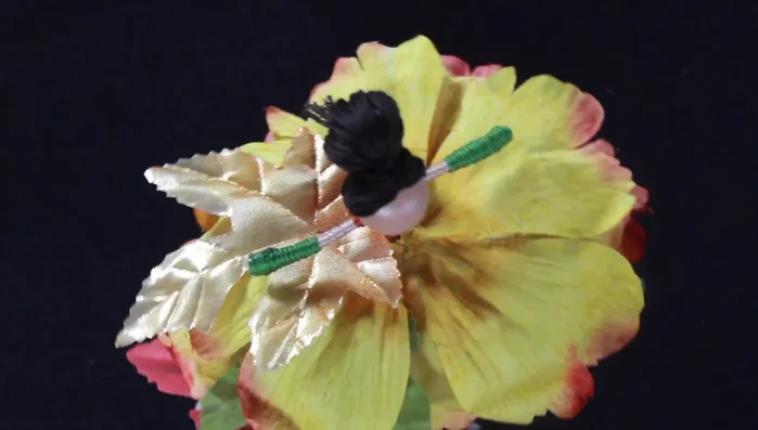 Incorporate additional embellishments. Tuck small leaves and foliage underneath and on top of the flower petals for added detail and visual interest.