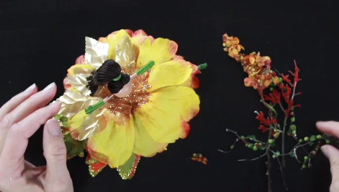 Create a hairpiece. Use small pieces of green, red, and orange foliage to create a unique hair accessory, adding small amounts of gold glitter.