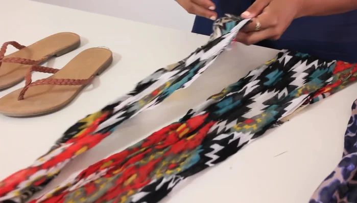 Cut a long scarf in half lengthwise to create two equal pieces.