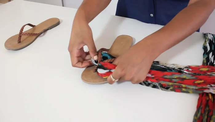 Slide the ends of the scarf through the loop you just created, securing it around the flip-flop's thong.