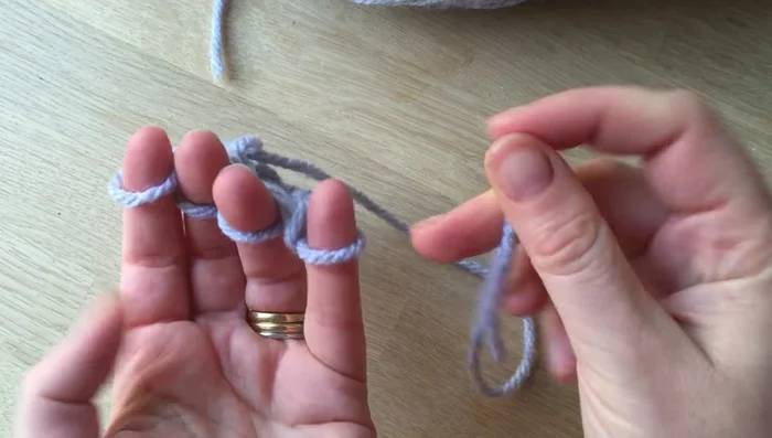 Cut a long piece of wool and weave it through each loop to secure the knitted piece. Pull tight.