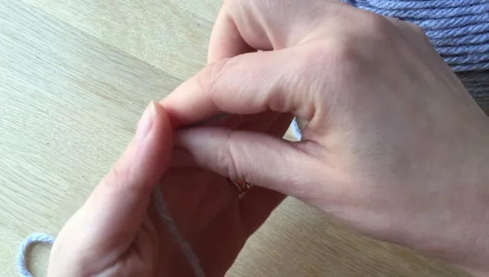 Cut a long piece of wool and weave it through each loop to secure the knitted piece. Pull tight.